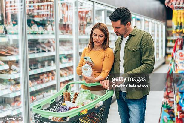 couple shopping in supermarket - buy online pick up in store stock pictures, royalty-free photos & images