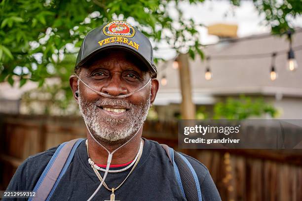 retrato ao ar livre, veterano da marinha afro-americano em seus setenta anos, usando máscara de oxigênio e chapéu militar - oxigênio fenômeno natural - fotografias e filmes do acervo