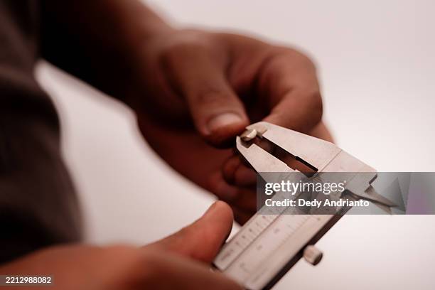 nahaufnahme des handwerklichen messschmucks weißgoldbarren mit messschieber - schieblehre stock-fotos und bilder