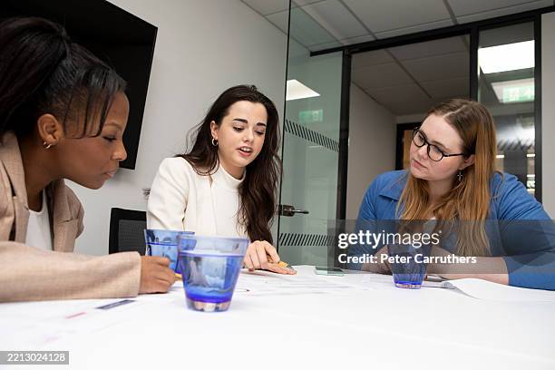 young businesswomen working together at an office meeting - alleen jonge vrouwen stockfoto's en -beelden