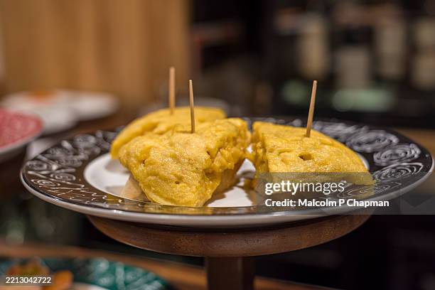 typical pintxos (tapas) tortilla on bread - san sebastian, donostia, basque region, spain - tortilla de patata fotografías e imágenes de stock