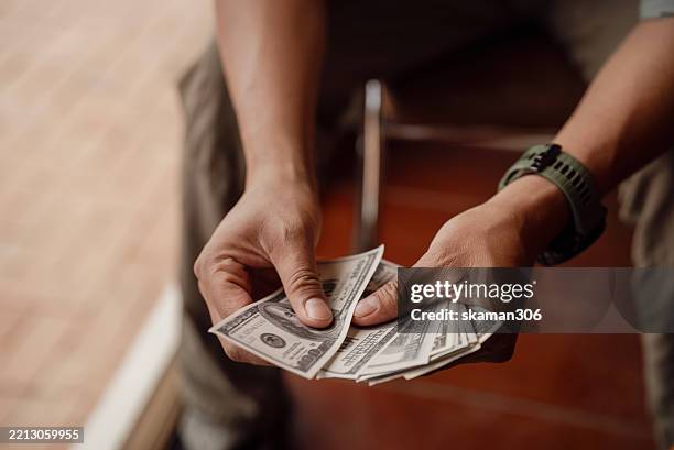 person holding and counting us dollar bills - unidade monetária dos estados unidos imagens e fotografias de stock