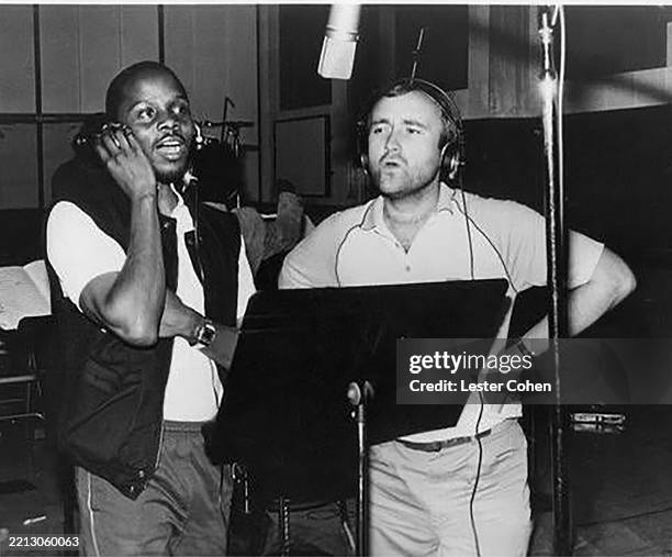 View of American R&B singer Philip Bailey and British musician & producer Phil Collins record a duet in an unspecified studio, Los Angeles,...