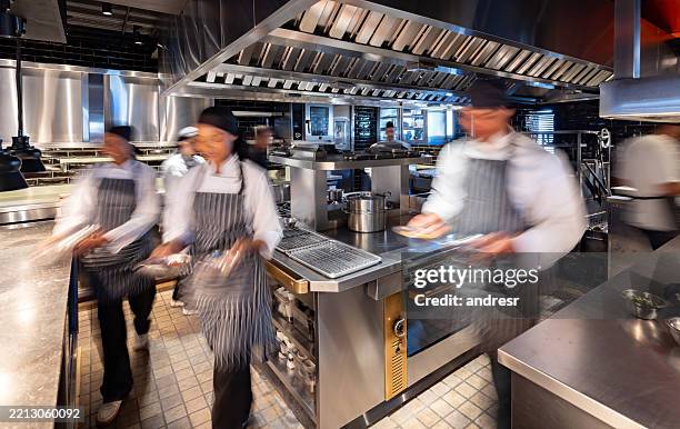 blurred motion at a busy commercial kitchen - commercial kitchen stock pictures, royalty-free photos & images