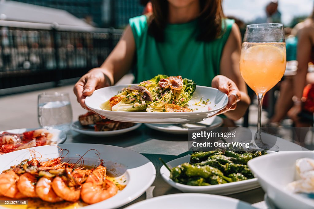 Cropped shot of woman eating Spanish Tapas at outdoor restaurant