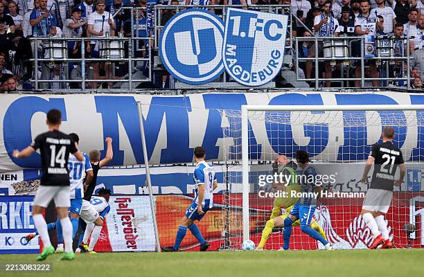 Marc Lorenz of 1. FC Magdeburg scores his team's second goal past Johannes Schenk of SC Preuben Munster during the Second Bundesliga match between 1....