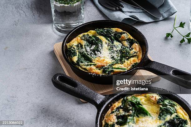 spinach frittata in cast iron pan on grey background - ketogenic diet stock pictures, royalty-free photos & images