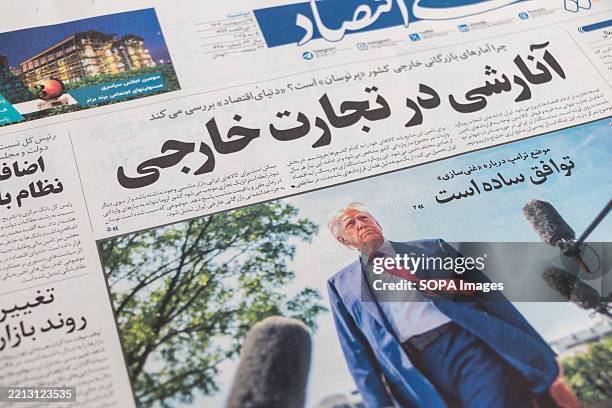 The front page of an Iranian newspaper is seen displayed at a newsstand, featuring a photo of U.S. President Donald Trump alongside a headline...