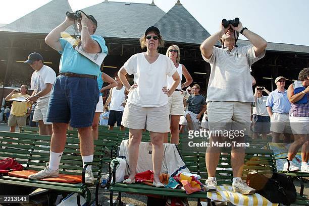 Spectators view the action at Saratoga Race Course during opening weekend of the thoroughbred racing season July 26, 2003 in Saratoga Springs, New...