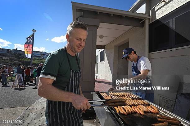 Volunteers cook sausages as people queue to vote at the Clovelly Surf Life Saving Club polling booth on May 03, 2025 in Sydney, Australia....