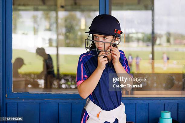 young female cricket player putting her helmet on - cricket field stock pictures, royalty-free photos & images