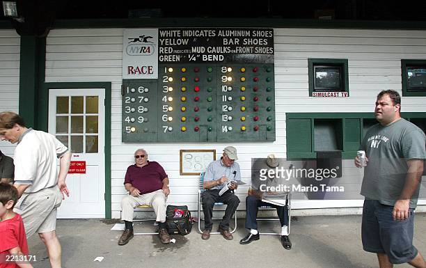 Men review tip sheets at Saratoga Race Course during opening weekend of the thoroughbred racing season July 26, 2003 in Saratoga Springs, New York....