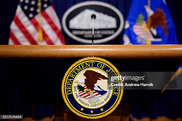 The Department of Justice seal and logo are displayed before U.S. Attorney General Pam Bondi arrives for a news conference at the Department of...