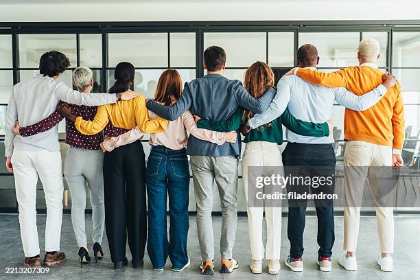 vereintes business-team, das sich gemeinsam umarmt - menschenreihe stock-fotos und bilder