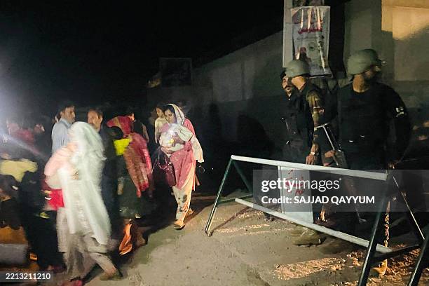 Security personnel cordon-off a street as local residents evacuate their homes near the site of a strike in Muzaffarabad, the capital of...