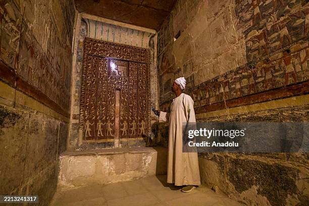 Man points at an ancient wall painting from Zoser Pyramid at the historical Saqqara region, which is home to the majority of historical artifacts...