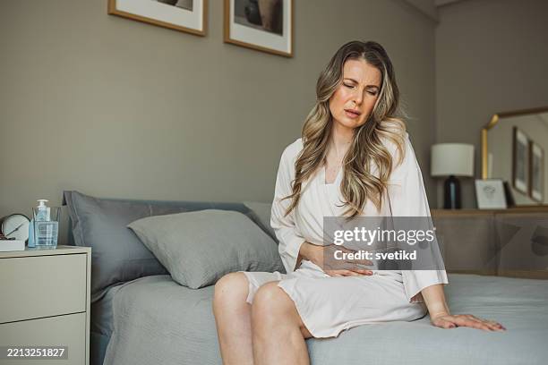 reife frau mit bauchschmerzen - symptom stock-fotos und bilder