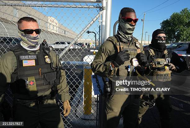 Immigration and Customs Enforcement agents stand near a gate at Delaney Hall, a newly converted immigrant detention centre in Newark, New Jersey May...