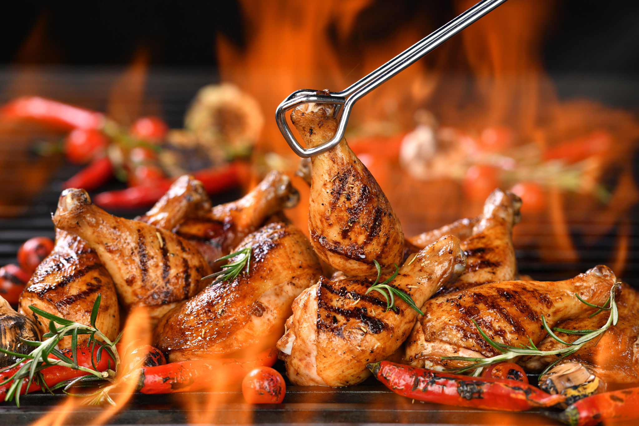 Grilled chicken legs and chicken thighs on the flaming grill Grilled chicken legs and chicken thighs on the flaming grill