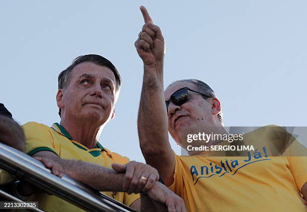 Brazil's former President Jair Bolsonaro speaks with Brazilian Pentecostal pastor and writer Silas Malafaia during a march to demand amnesty for...