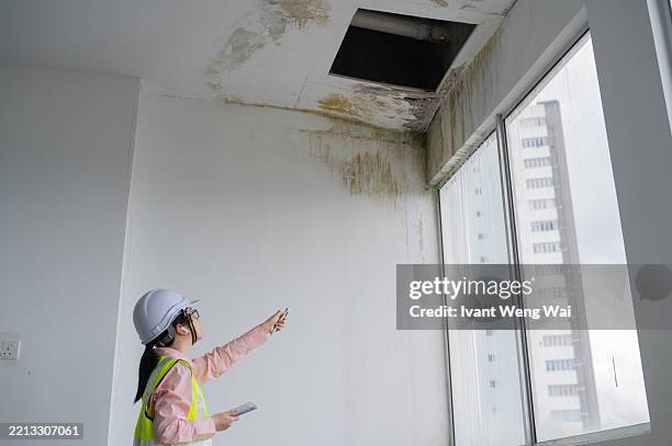 closeup asian chinese female construction inspector recording building defect list using smart tablet stock photo - poor quality stock pictures, royalty-free photos & images