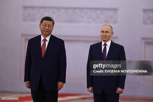 Russian President Vladimir Putin and his Chinese counterpart Xi Jinping attend a welcoming ceremony before their talks at the Kremlin in Moscow on...
