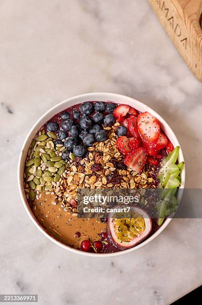 leckere acai bowl mit frischen früchten, granola und erdnussbutter-topping - superfood stock-fotos und bilder