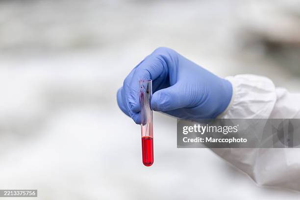 scienziato in tuta protettiva che analizza l'acqua inquinata - campione scientifico foto e immagini stock