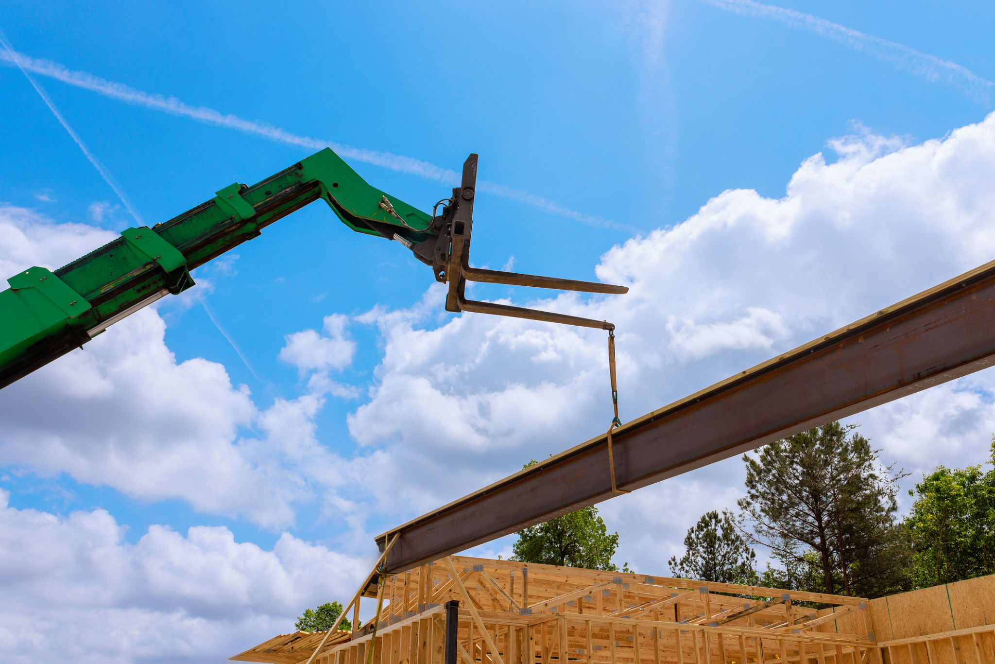 Construction telehandler crane lifts steel beam at building site Construction telehandler crane lifts steel beam at building site