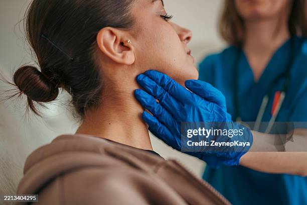 healthcare worker examining patient's throat - throat stock pictures, royalty-free photos & images