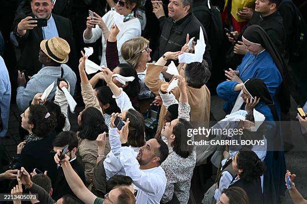 People react as white smoke signals that cardinals elected a new pope during their conclave in the Vatican on May 8, 2025.