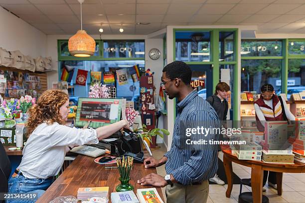 diverse group of people shopping in small local bookstore - book shop stock pictures, royalty-free photos & images