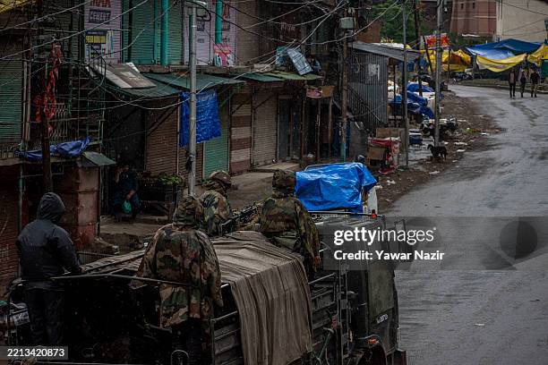 An Indian Army convoy carrying reinforcements and supplies drives near Pakistan-administered Kashmir. Stray dogs scavenge from garbage littered...