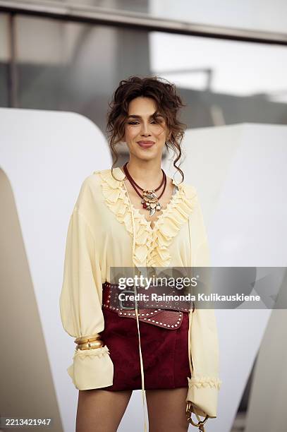Guest wears red mini skirt, butter yellow long sleeve shirt, red leather belt during day 2 of Visa Fashion Week Almaty 2025 on May 04, 2025 in...