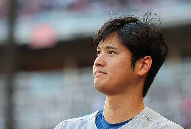Shohei Ohtani of the Los Angeles Dodgers reacts with his teammates at the end of the second inning against the Atlanta Braves at Truist Park on May...