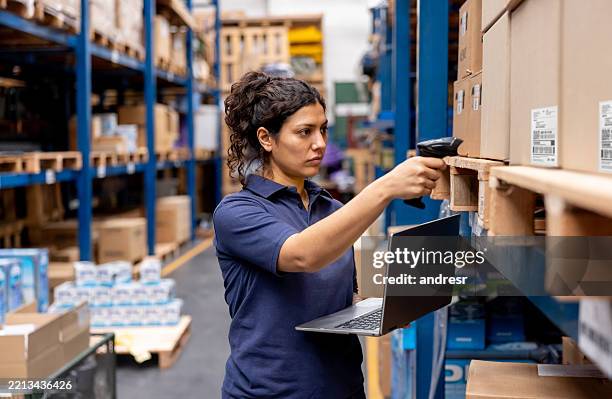 woman working at a warehouse and taking inventory using a bar code reader - taking inventory stock pictures, royalty-free photos & images
