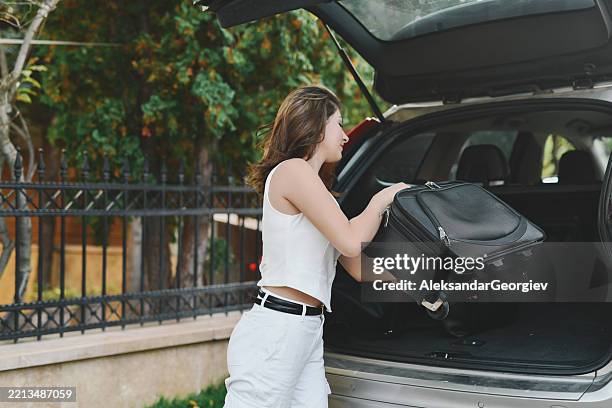 woman in business attire packing car for corporate trip - positioning stock pictures, royalty-free photos & images
