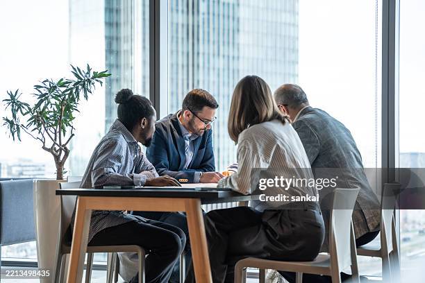 team collaboration in modern office with panoramic window view - task force stock pictures, royalty-free photos & images