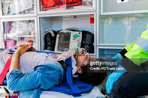 young victim man being helped by paramedics in ambulance - neck brace stock pictures, royalty-free photos & images