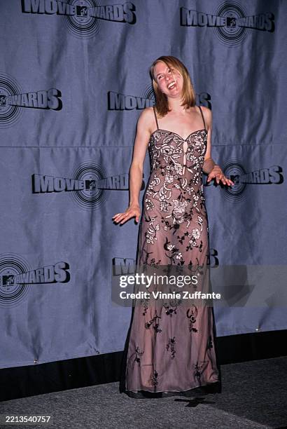 American actress Renee Zellweger, wearing a sheer grey evening gown with black and silver floral detail, in the 1997 MTV Movie Awards press room at...