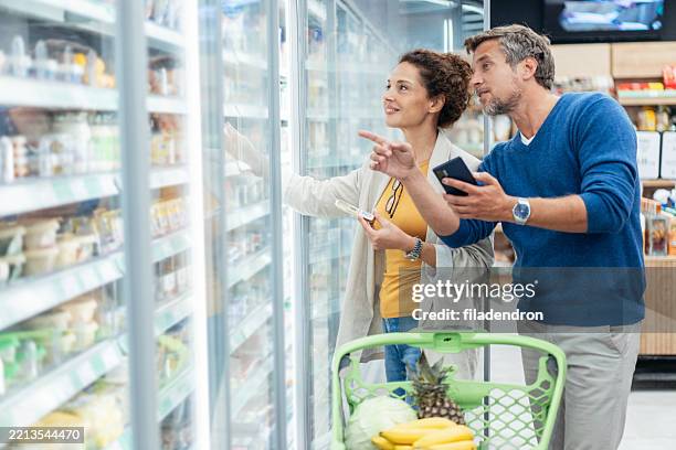 couple shopping in supermarket. - buy online pick up in store stock pictures, royalty-free photos & images