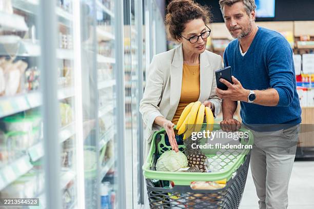 couple shopping in supermarket. - buy online pick up in store stock pictures, royalty-free photos & images