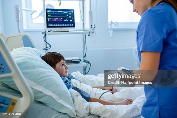 nurse taking boy’s blood pressure during medical check-up. - paediatrician stock pictures, royalty-free photos & images