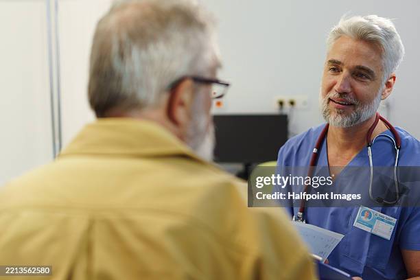 hansome doctor consulting with senior patient. - cholesterol stockfoto's en -beelden
