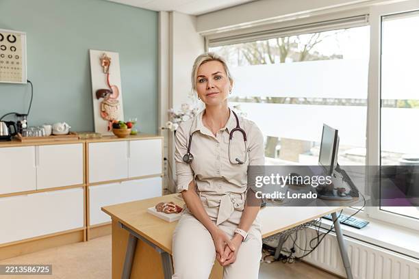 a beautiful female dietician nutritionist in her medical practice - nederlandse cultuur stockfoto's en -beelden