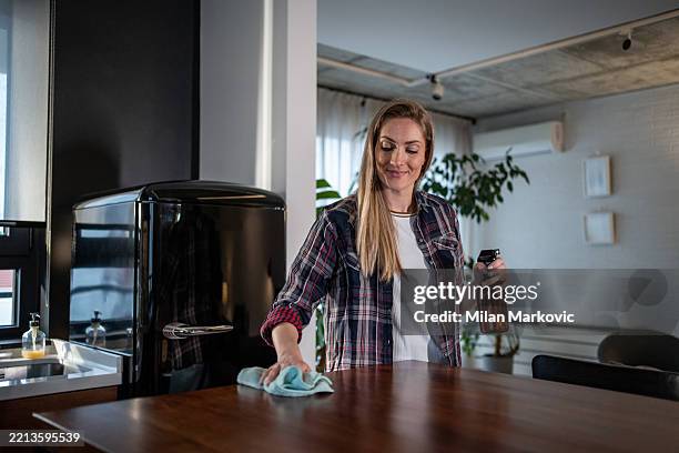 frau reinigt küchentheke mit sprühflasche - spültuch stock-fotos und bilder