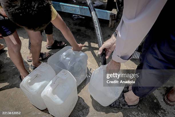 Displaced Palestinians fill their water canisters from an aid truck to provide drinking water at Jabalia Refugee Camp in Jabalia, Gaza on May 09,...