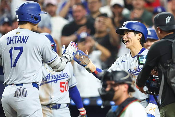 Shohei Ohtani of the Los Angeles Dodgers celebrates with teammate Hyeseong Kim after hitting a home run against the Miami Marlins in the fifth inning...