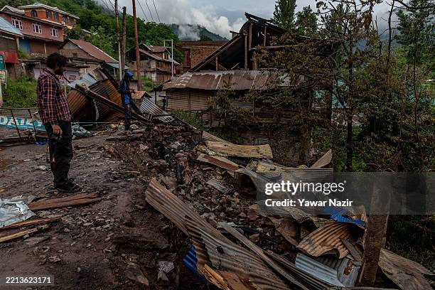 Photographer looks on at a residential house destroyed by artillery shelling allegedly carried out by Pakistani forces in the town of Uri, near the...