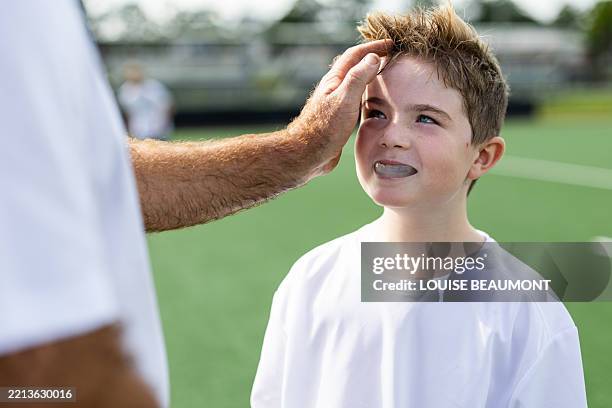 father and son field hockey players take a break - gum shield stock pictures, royalty-free photos & images